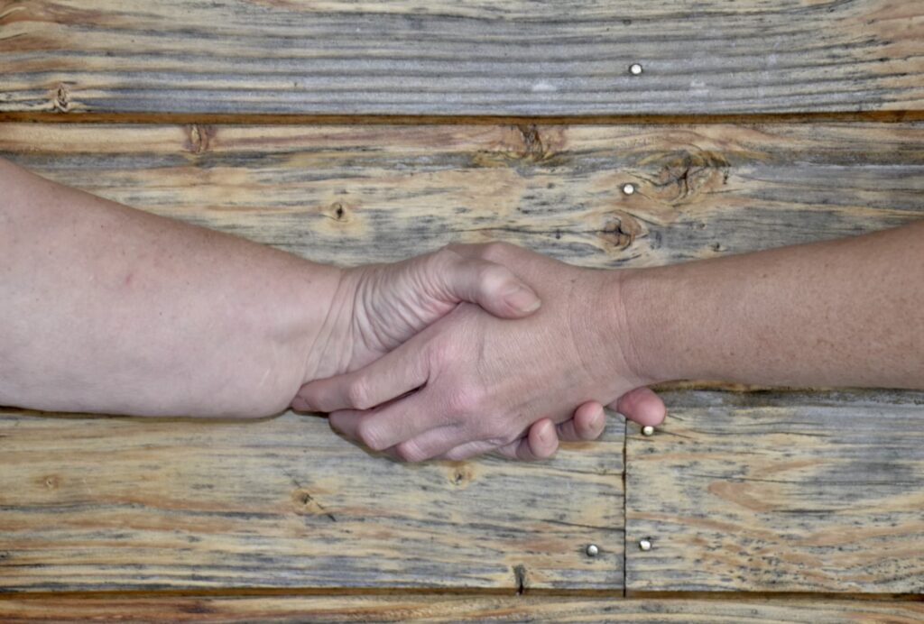 Deux personnes qui se se serrent la main. On ne voit que leur bras et mains.