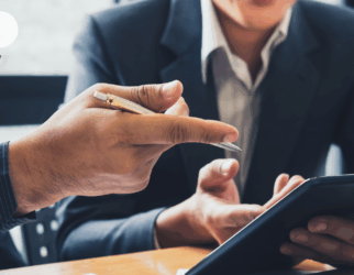 Mocalina, consulting et formation. Manager une personne en situation de handicap. Photographie avec deux personnes qui travaillent sur un ordinateur. On ne voit que leur main et un bout de leur torse. Ils sont habillés en costume